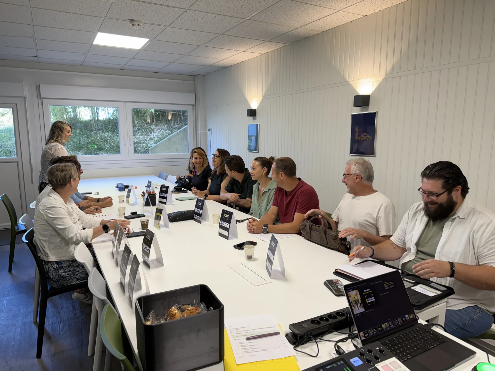 Membres attablés avec chevalets de prénoms pendant une réunion